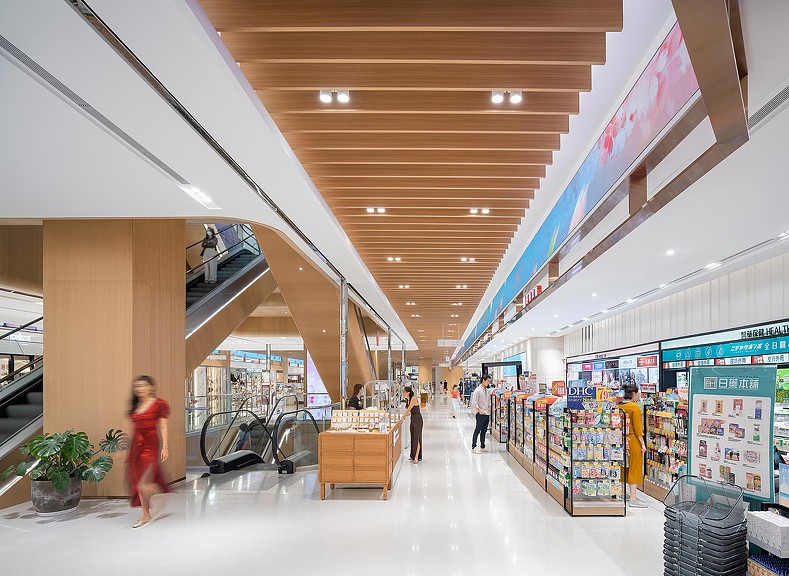 A person in a red dress walking through a shopping mall.